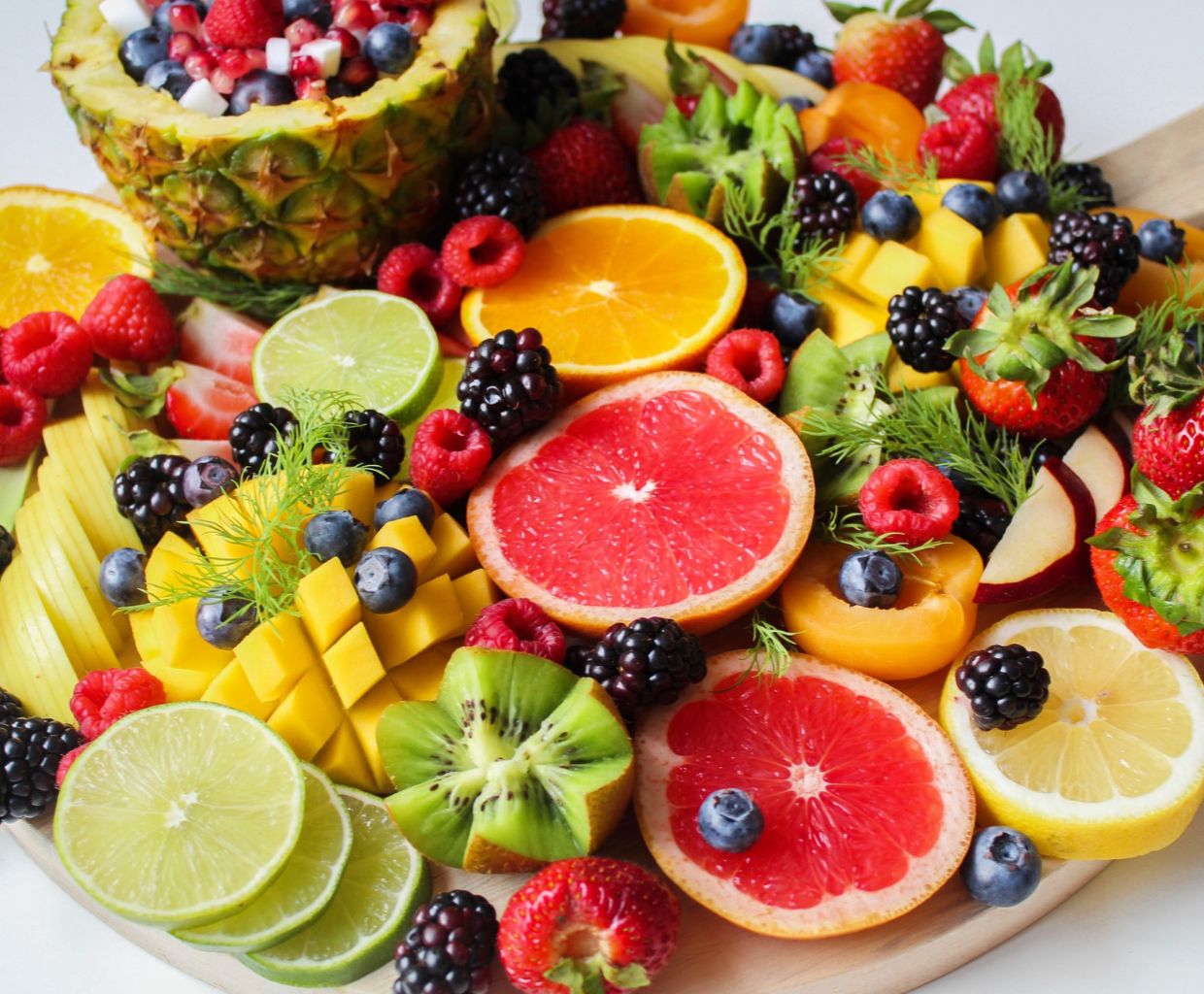 Colorful platter of fresh fruit including oranges, berries, kiwi, mango and grapefruit