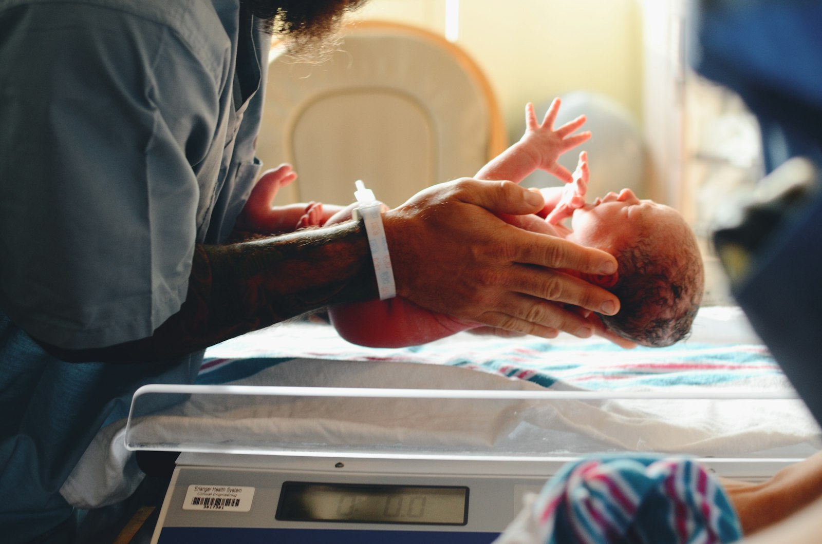 Hospital staff weighing a newborn baby on a scale