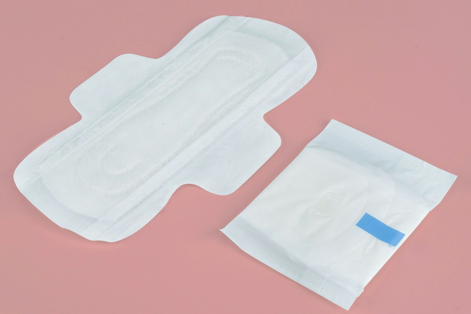Two sanitary pads on a pink background