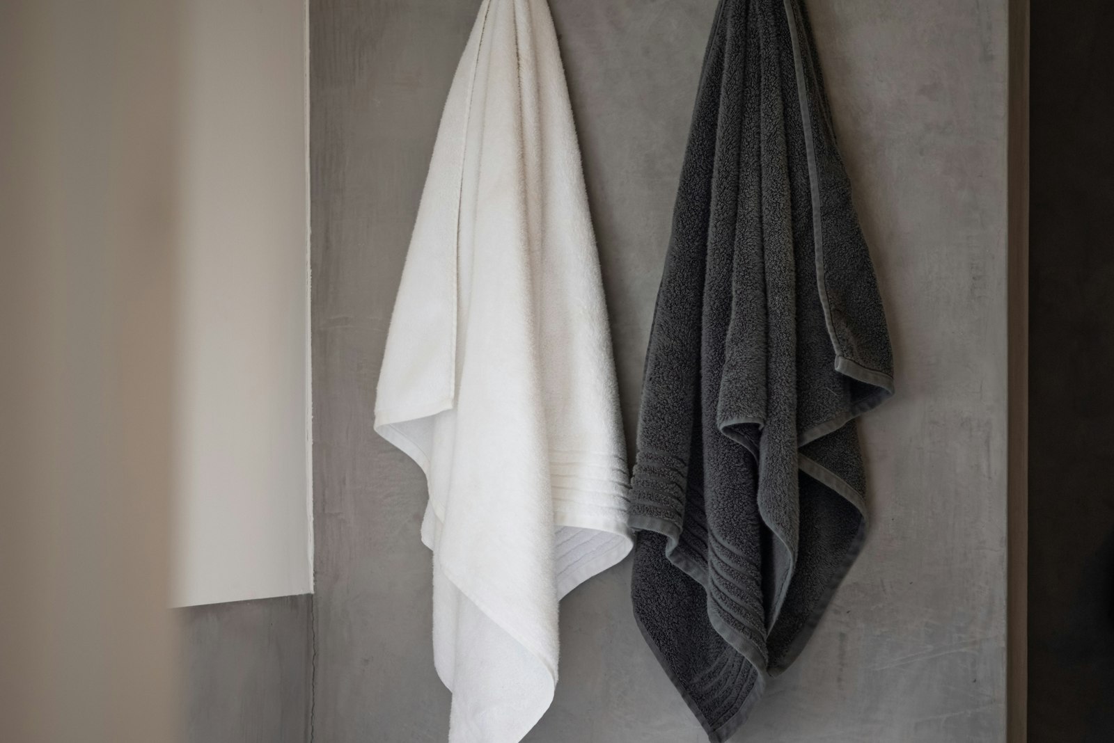 White and gray towels hanging in a bathroom
